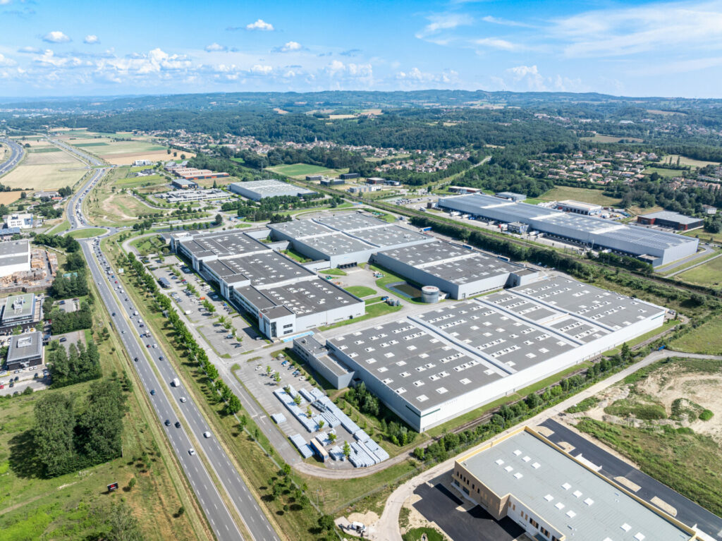 Photo drone d'un parc d'entrepôts logistiques vers Lyon, avec la nationale au premier plan