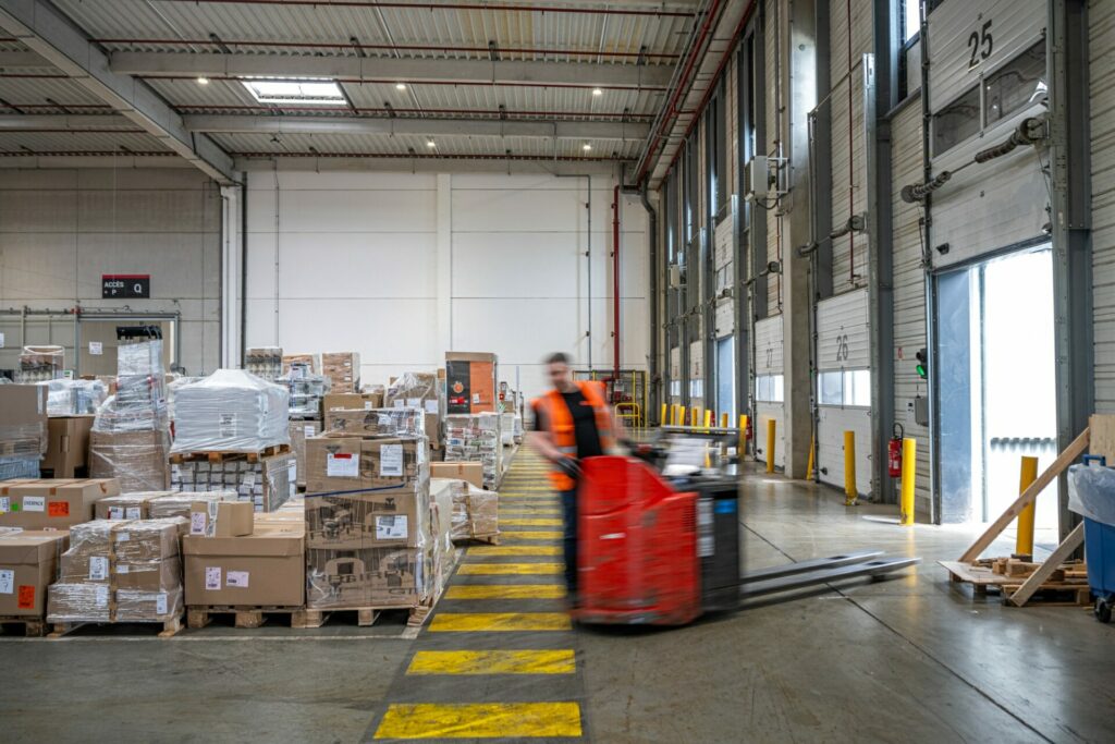 Photographie intérieure d'un entrepôt logistique, avec un transpalette en flou de mouvement