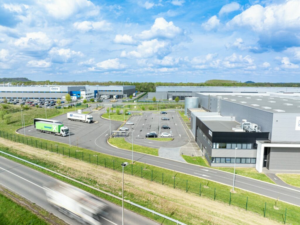 Photographie drone d'un entrepôt logistique avec un camion en mouvement passant devant