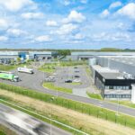 Photographie drone d'un entrepôt logistique avec un camion en mouvement passant devant