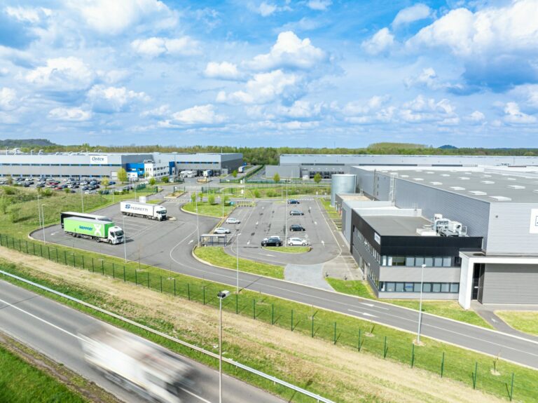 Photographie drone d'un entrepôt logistique avec un camion en mouvement passant devant