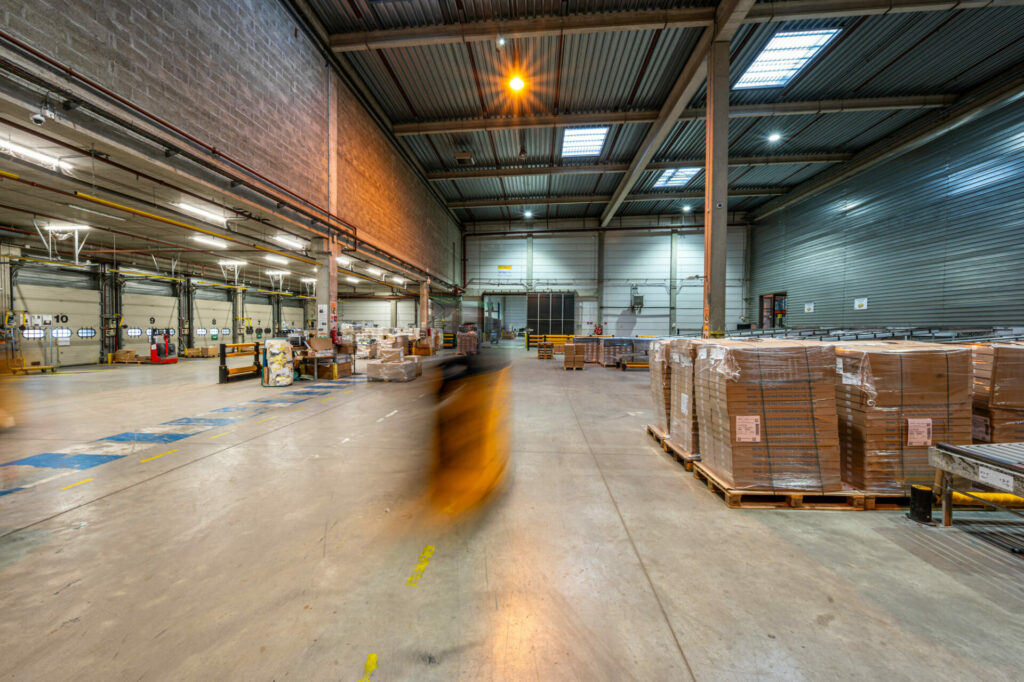 Intérieur d'un entrepôt logistique avec un transpalette en mouvement