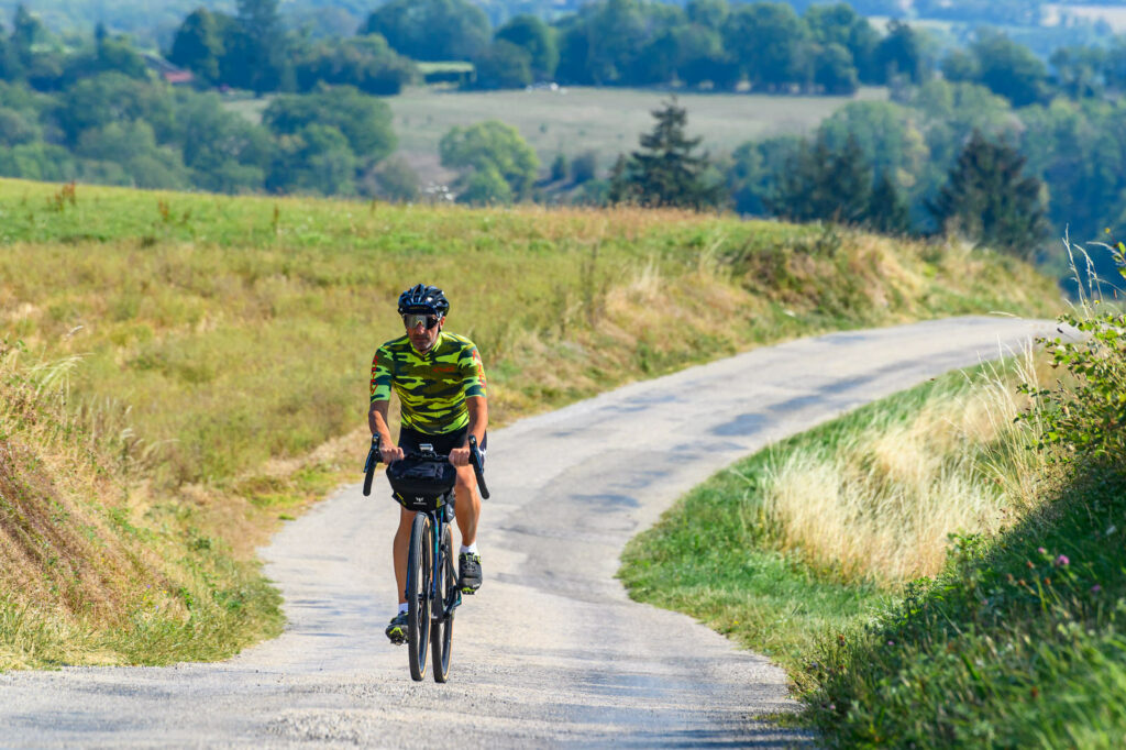 Cycliste en Gravel sur une route secondaire, dans la campagne